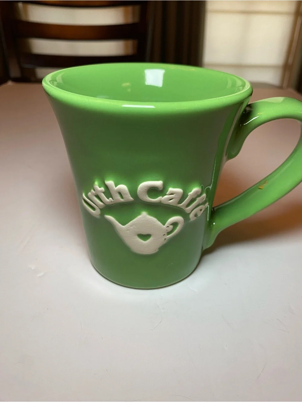 Urth Cafe ceramic coffee mug in green with white embossed logo